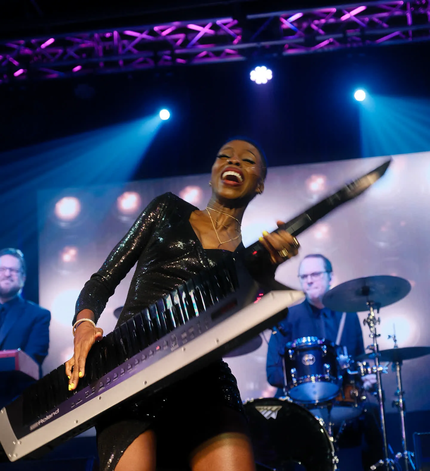 Live Music Society performer on keytar mid-song under Las Vegas stage lights